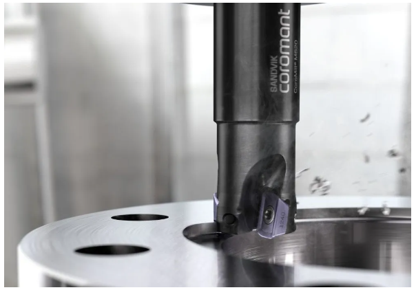 Sandvik Coromant end mill machining a precision metal component.